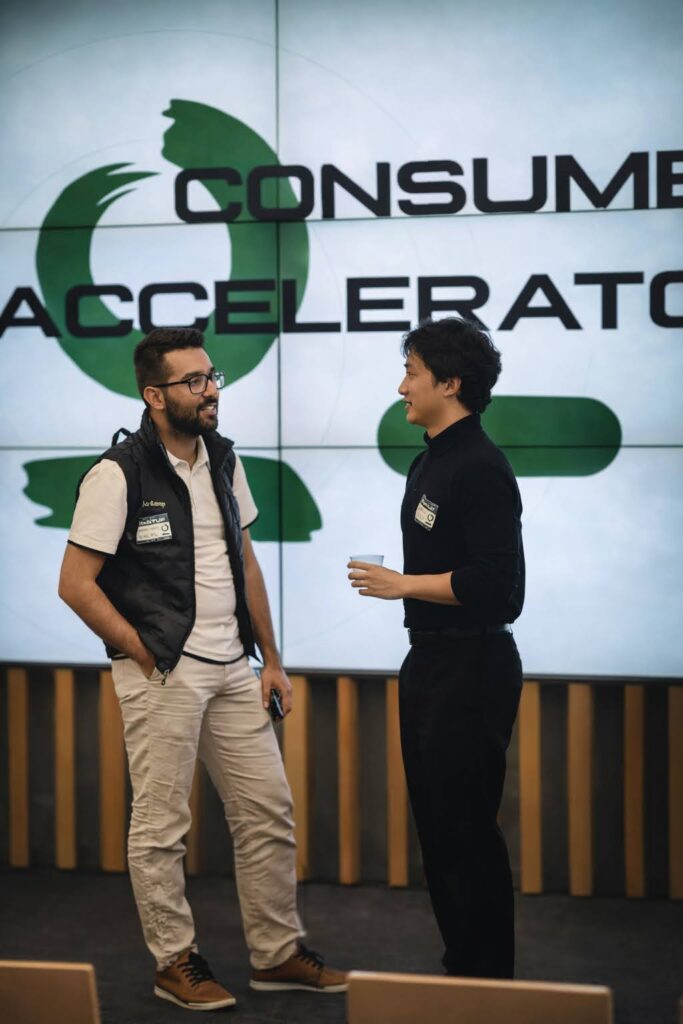 Two people speaking on a small event stage.